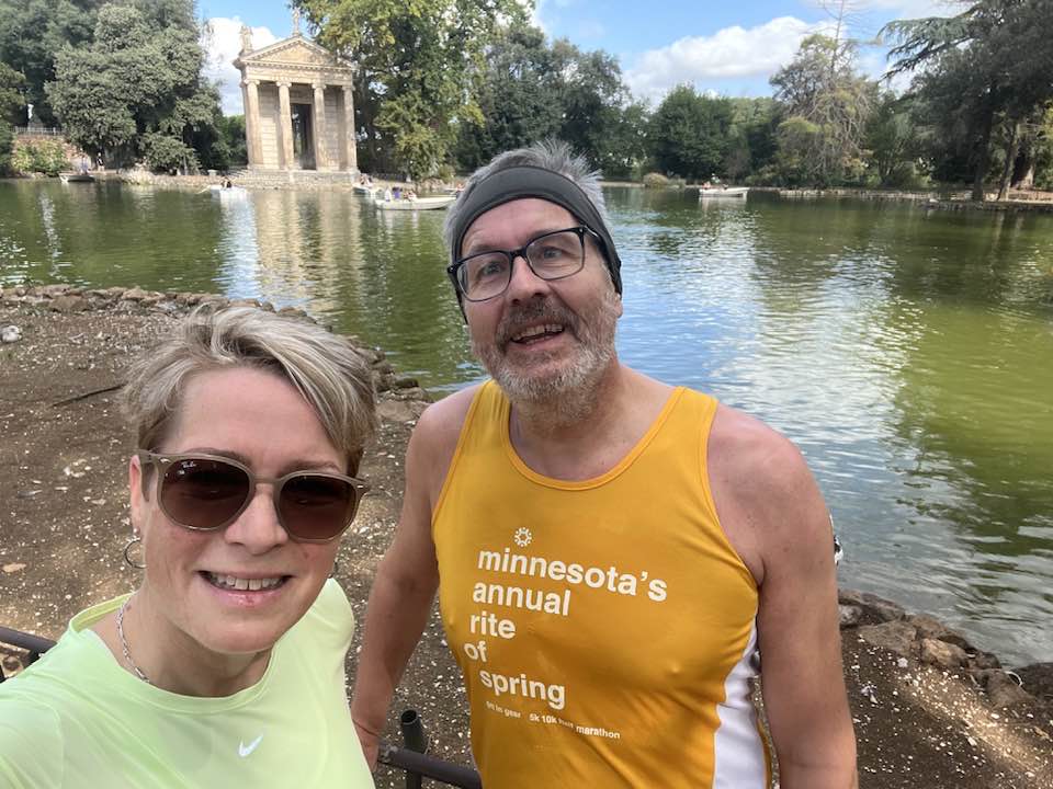 Sjálfa af Siggu og Dúa við lítið vatn í Borghese-garðinum í Róm. Þau eru í hlaupafötum.