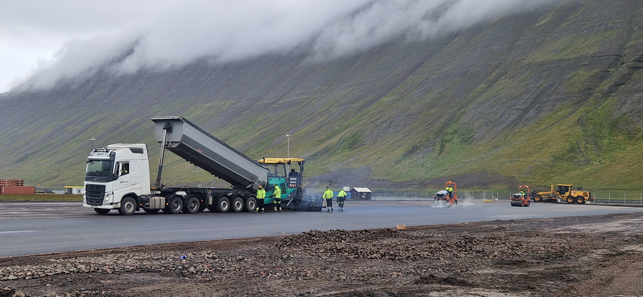 Malbikunarframkvæmdir á Suðurtanga á Ísafirði. Vörubíll, valtari og vinnumenn eru á myndinni.